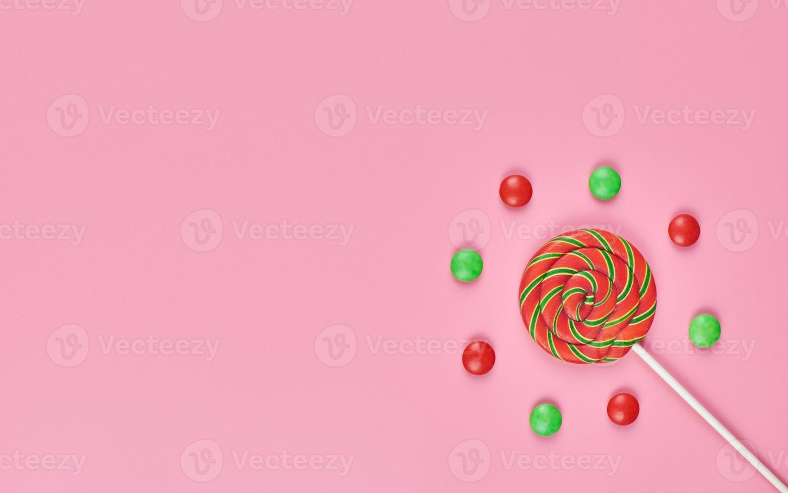 Sweet lollipop and candy on pink background photo