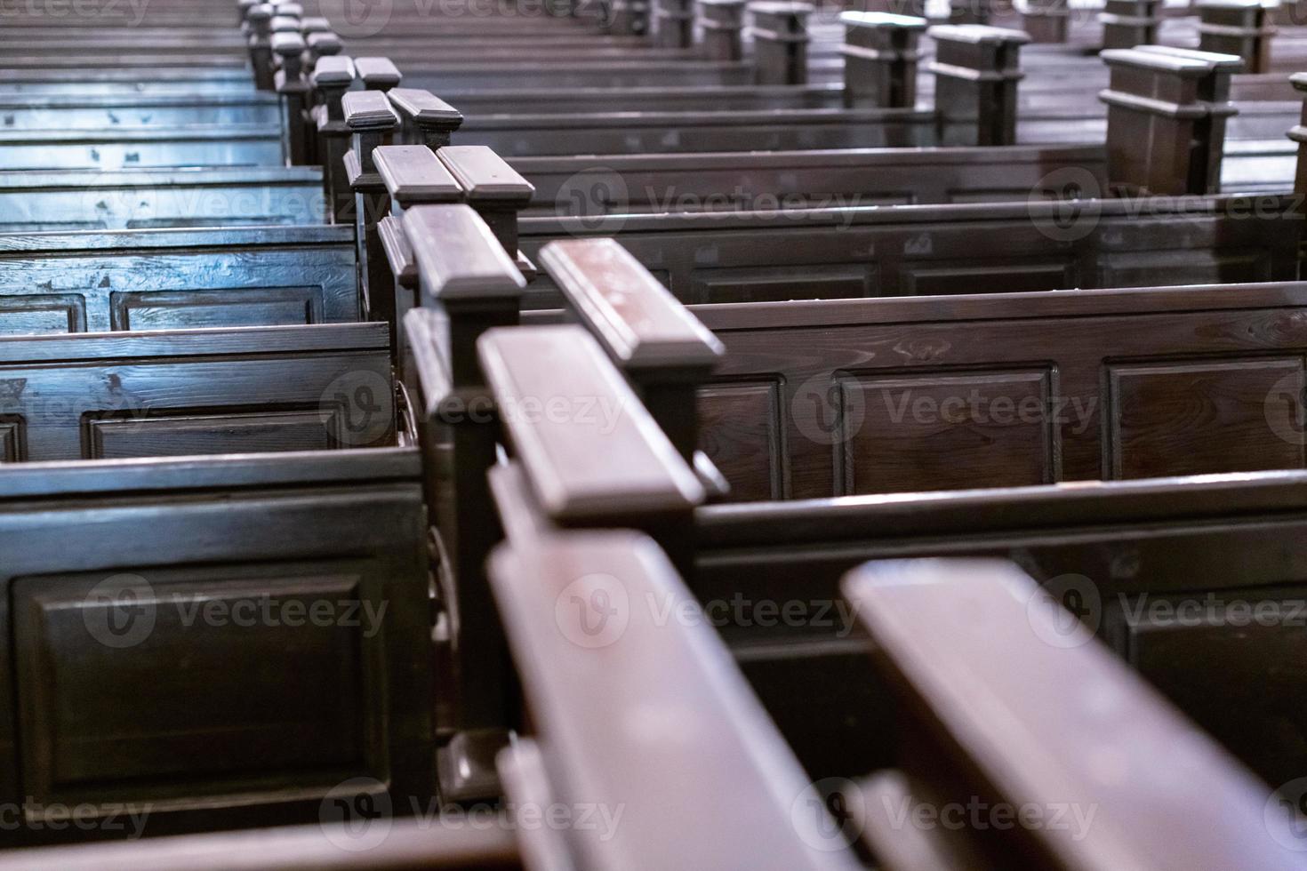 Cathedral pews. Rows of benches in christian church. Heavy solid uncomfortable wooden seats. photo