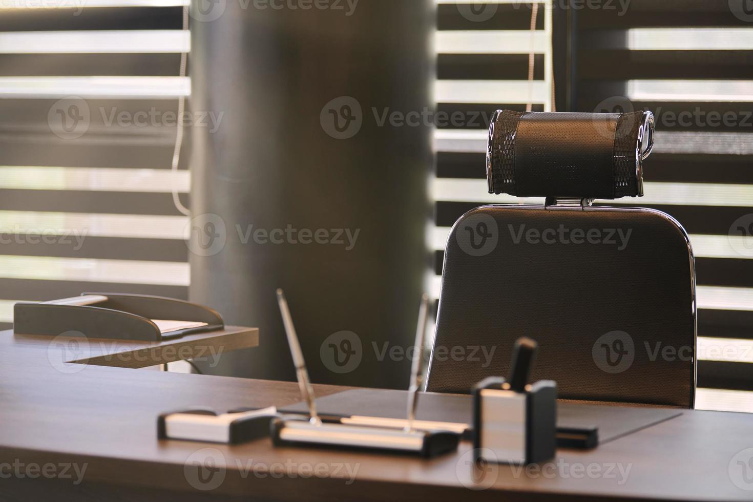 lugar de trabajo de la oficina de negocios. luz solar en el lugar de trabajo para jefe, jefe u otros empleados. mesa y silla cómoda. luz a través de las persianas entreabiertas foto