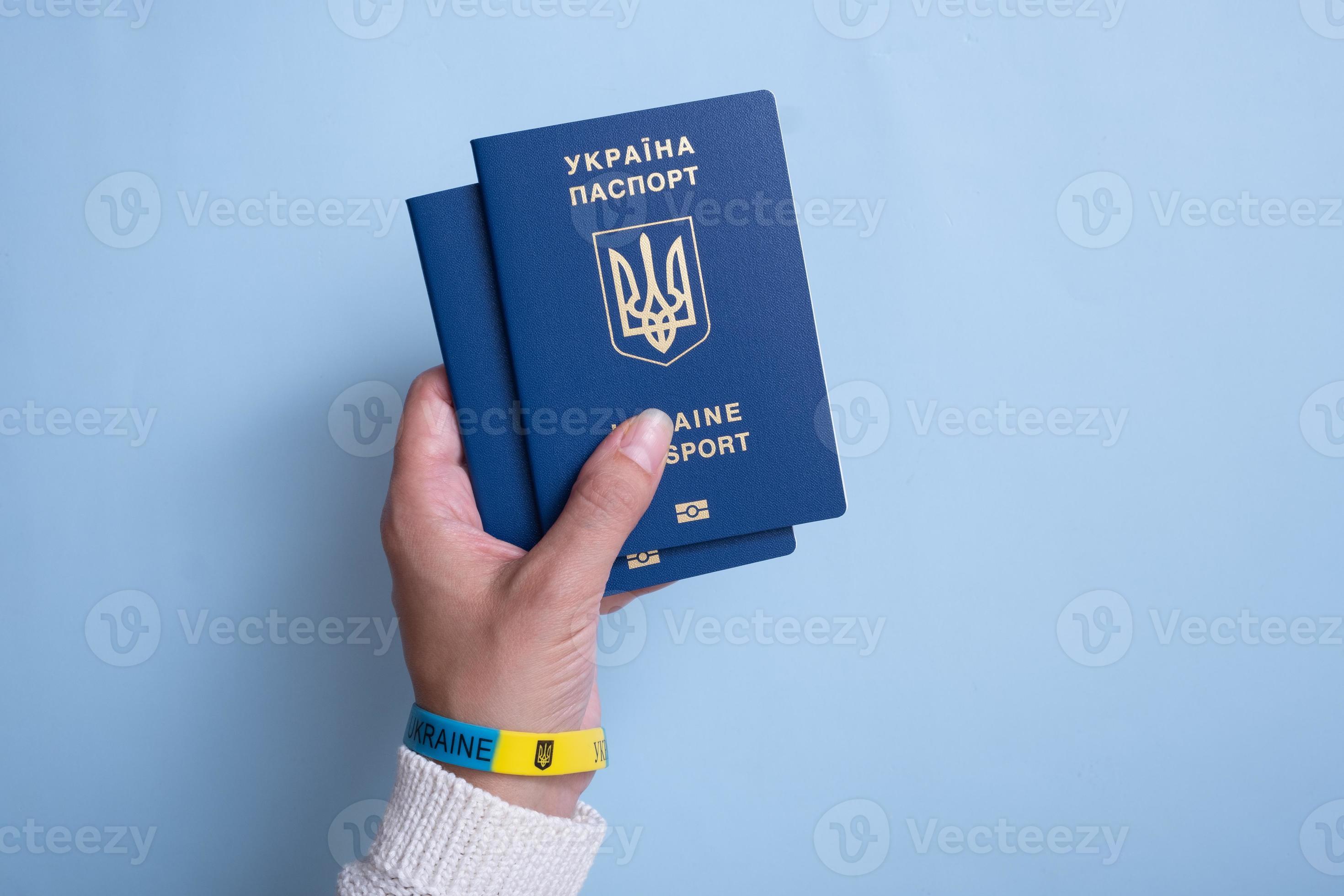 Passports of a citizen of Ukraine and female hand on a blue background