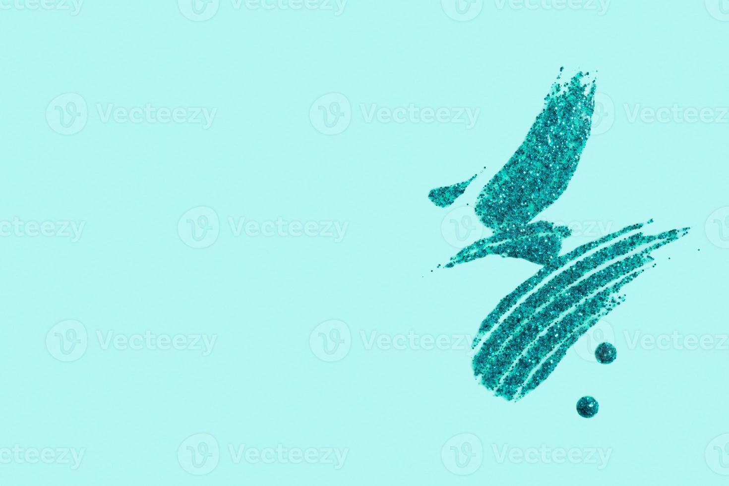 Turquoise glitter smear on colored background top view with copy space. Christmas glitter element photo