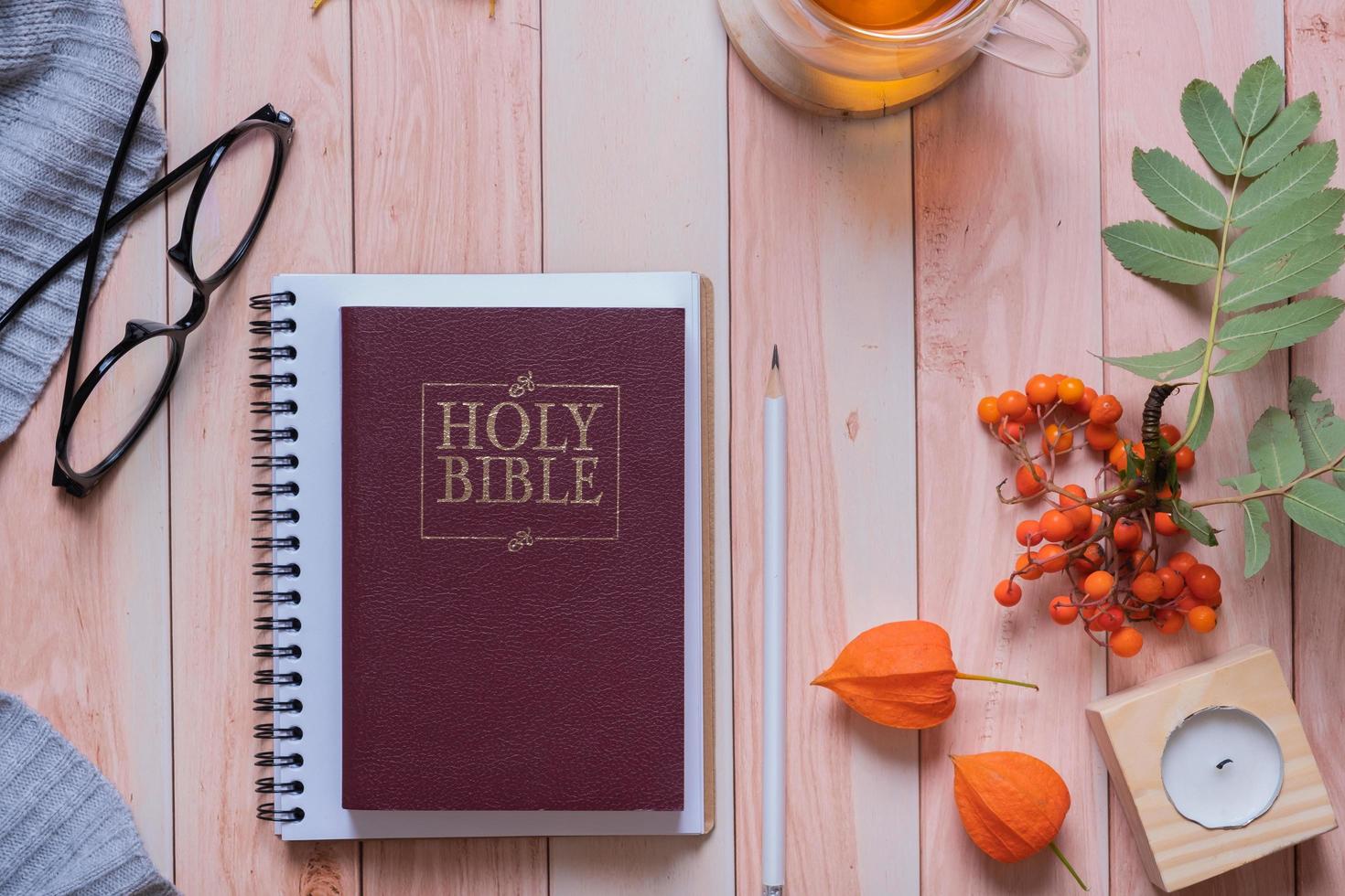 Holy bible and autumn cozy top view on wooden background. Bible study autumn concept photo