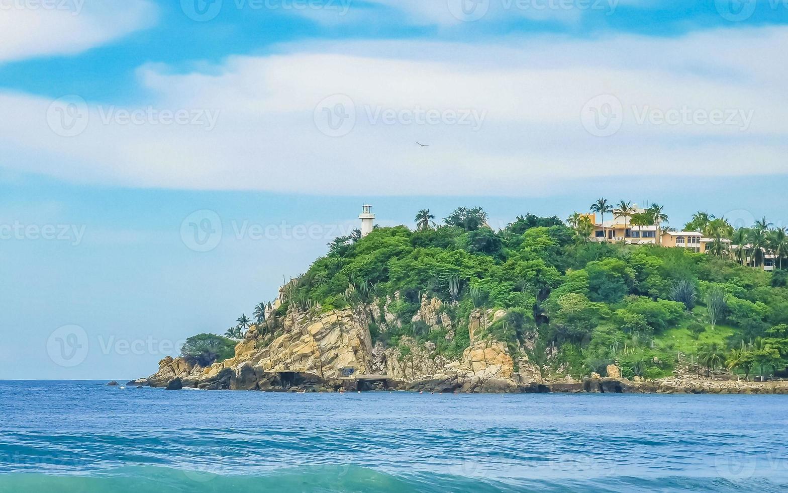 Beautiful surfer waves rocks cliffs at beach Puerto Escondido Mexico. photo