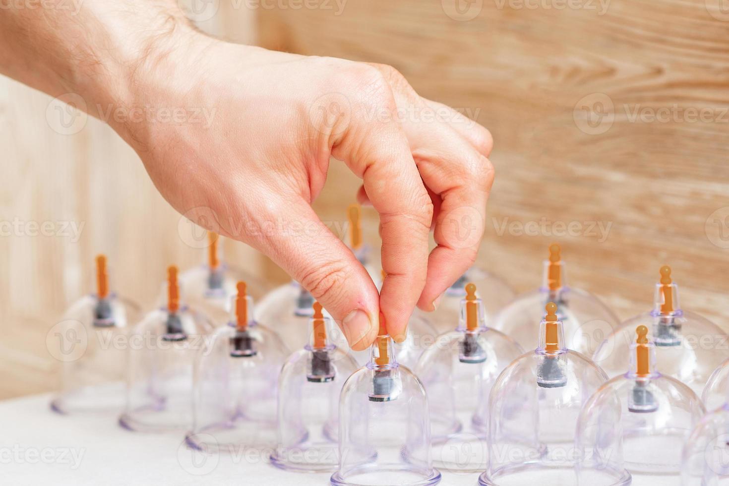 hand of massager taking vacuum glass cup. photo