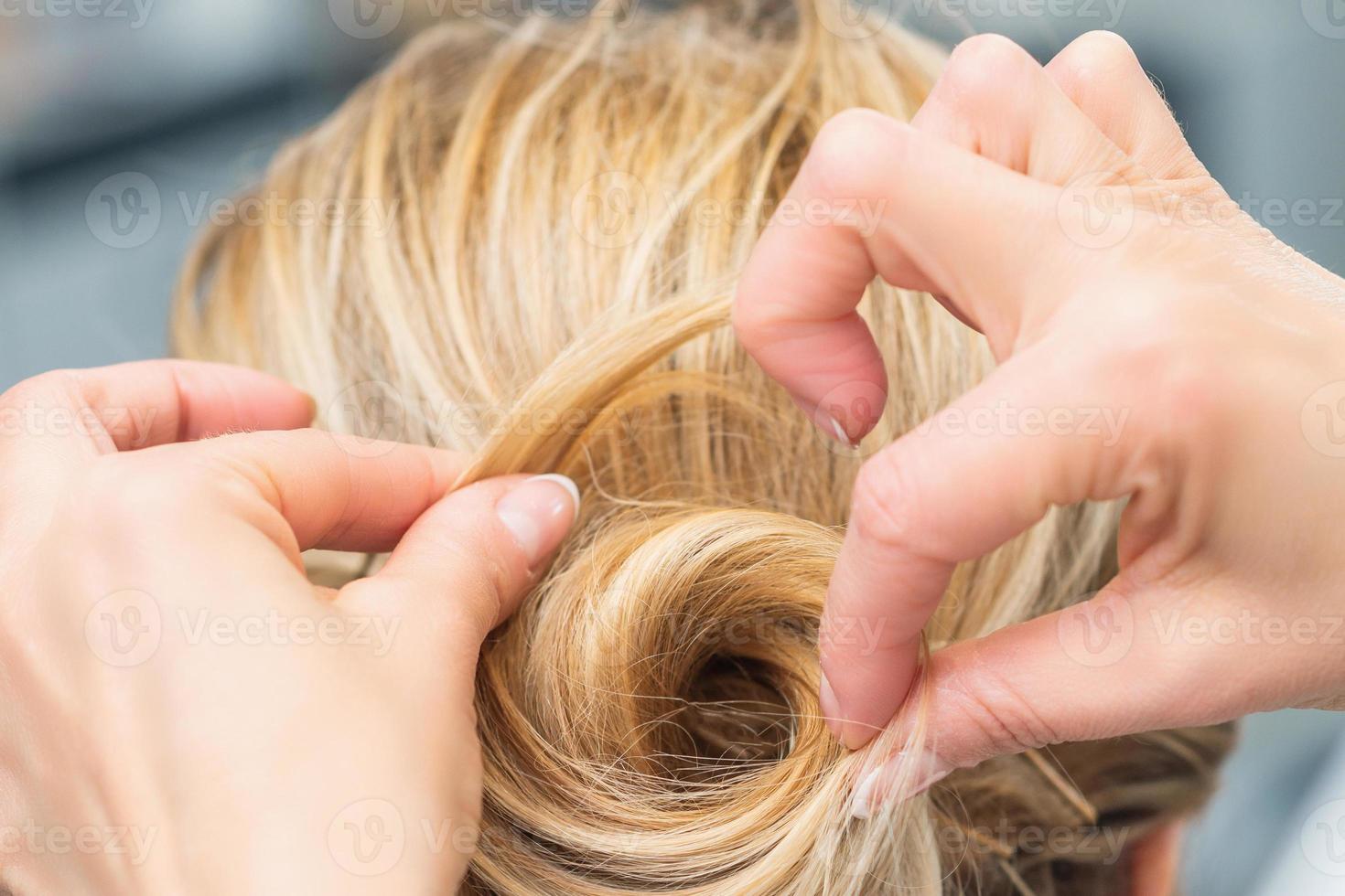 Hairstylist making bride wedding hairstyle photo