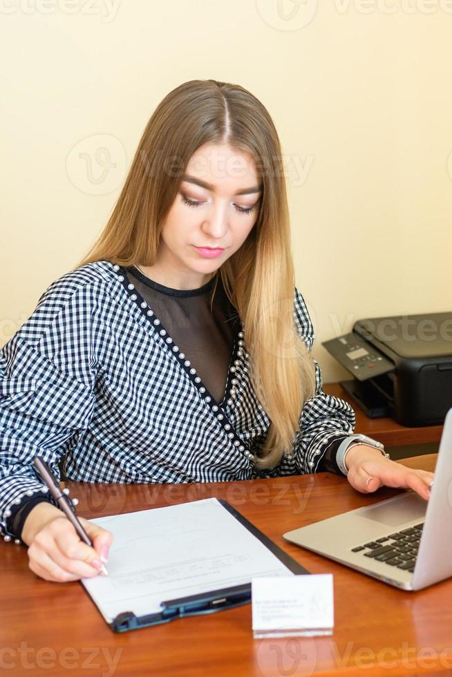 Business woman is writing on a document photo