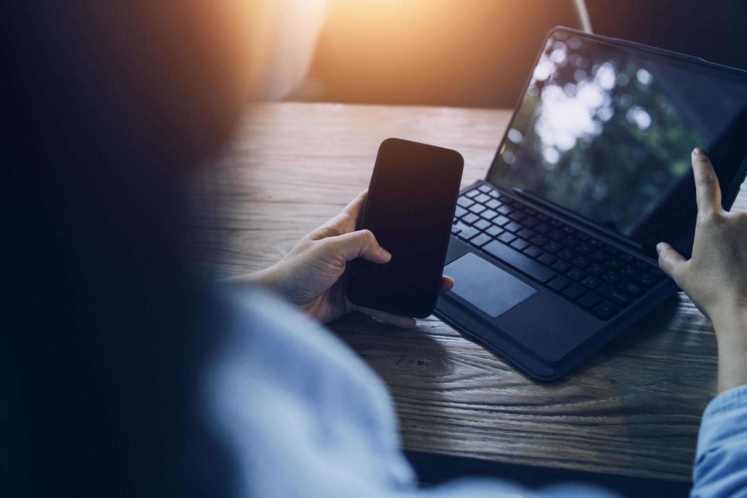 businesswoman hand working with laptop computer, tablet and smart phone in modern office with virtual icon diagram at modernoffice in morning light photo