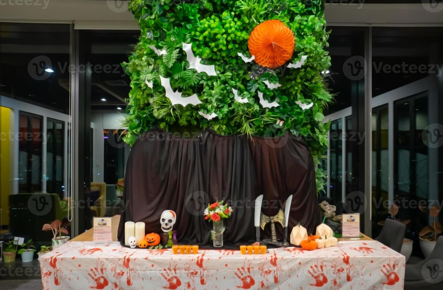 A picture of Halloween on the table with gourds skulls candles black cloth with leaves and bats on the back photo