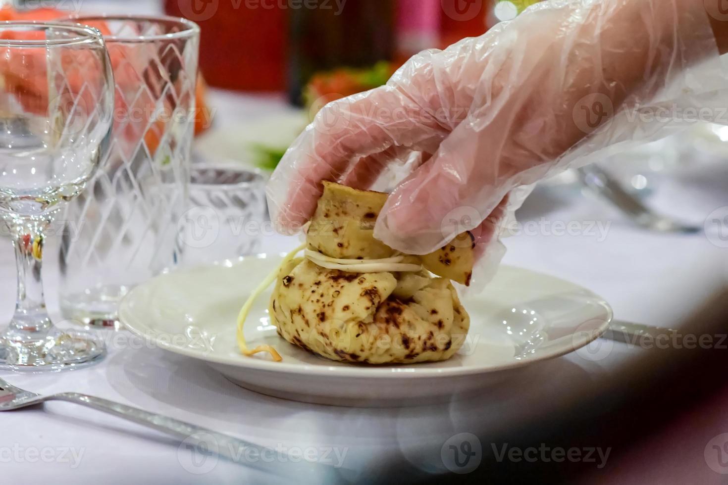 Table setting in a cafe. Bag of pancakes with filling on a plate. photo