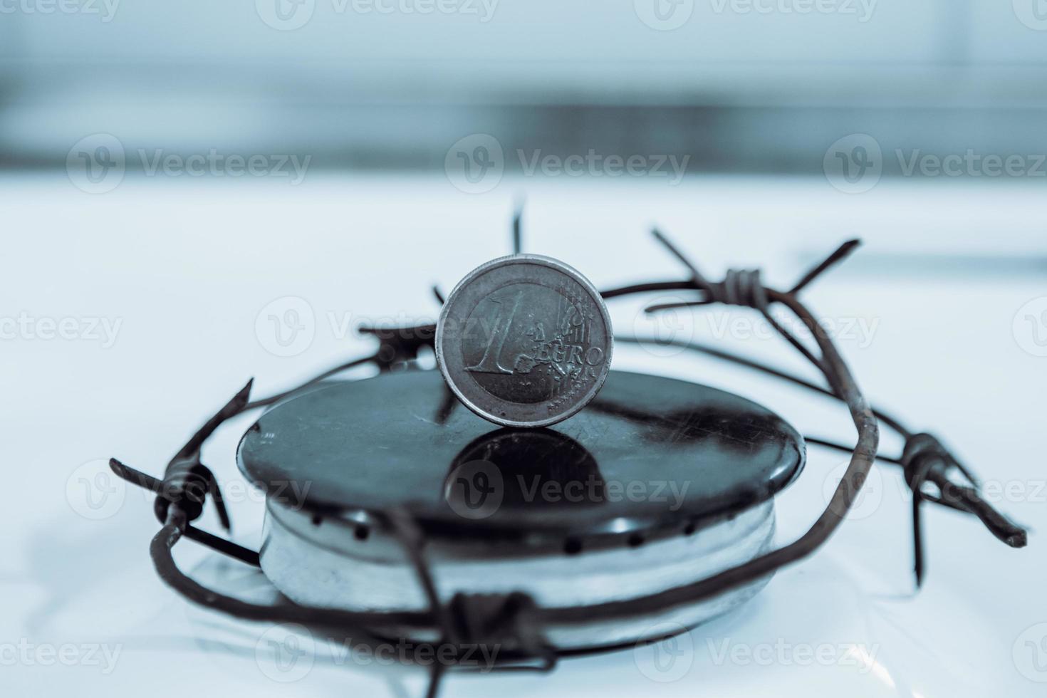 Restrictions causing shortages in gas supplies, burners Gas stove with barbed Wire and euro coin, concept gas crisis photo