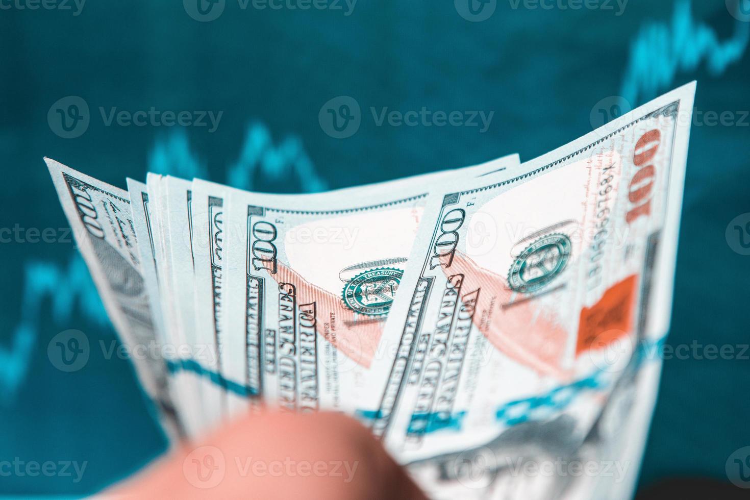 Right Hand Holds Stack of 100 Dollars Banknotes on black background, The 100 Dollar banknote is transferred by hand photo