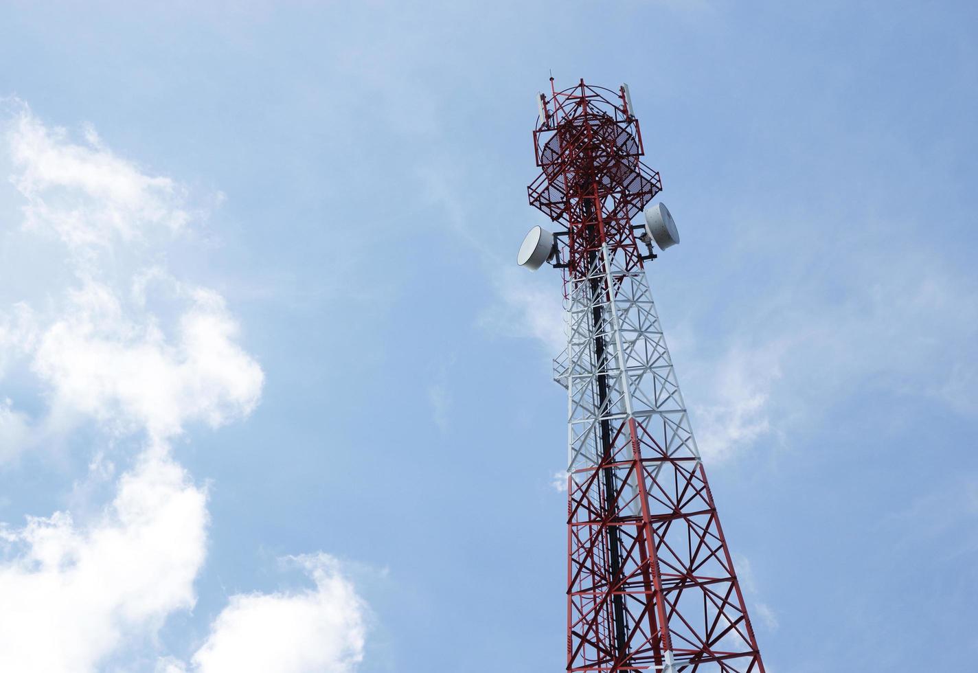 Telecommunications antenna for radio, television and telephone with cloud and blue sky photo