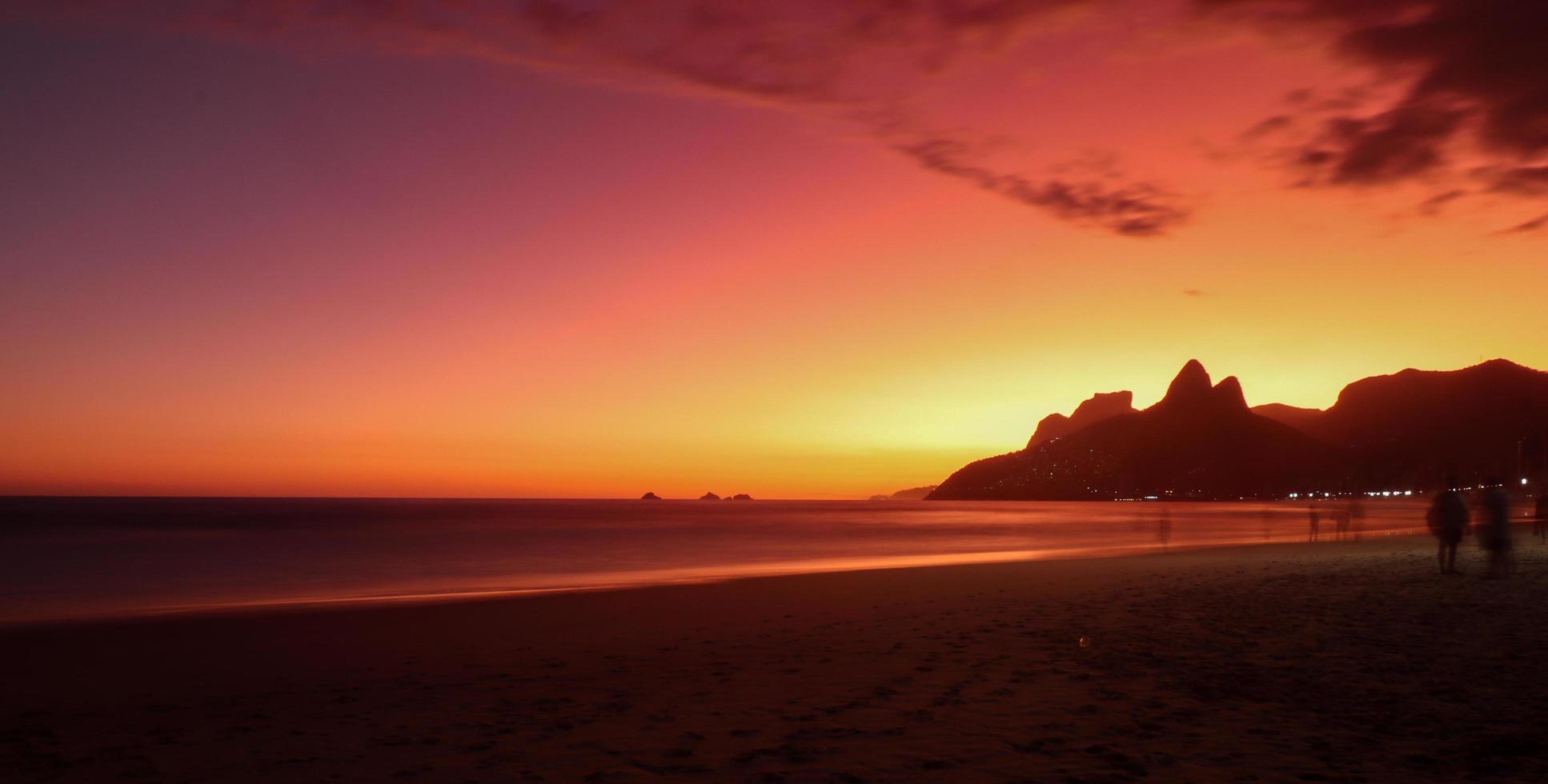 Rio de Janeiro, RJ, Brazil, 2022 - Ipanema at sunset, people walking on the beach in silhouette photo
