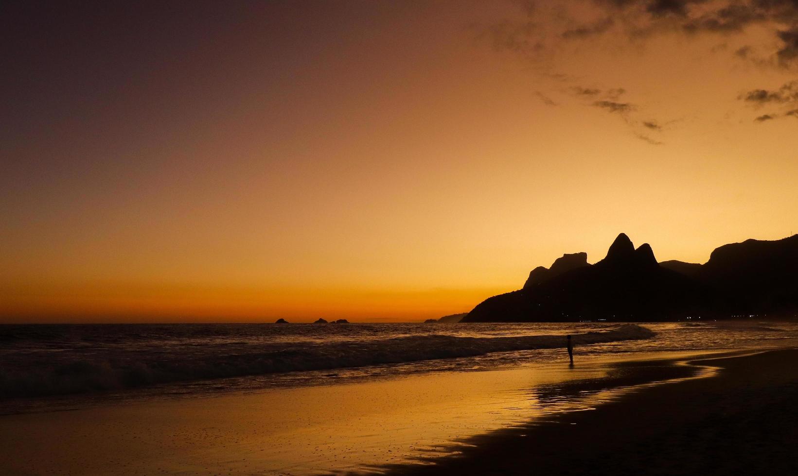 Rio de Janeiro, RJ, Brazil, 2022 - Ipanema at sunset, people walking on the beach in silhouette photo