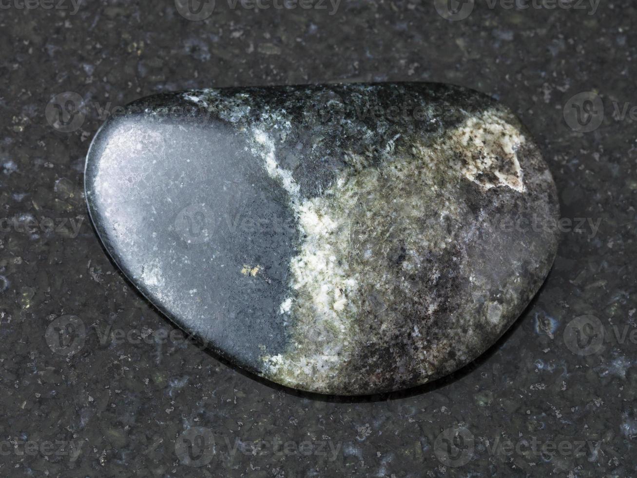 tumbled Olivenite stone on dark background photo