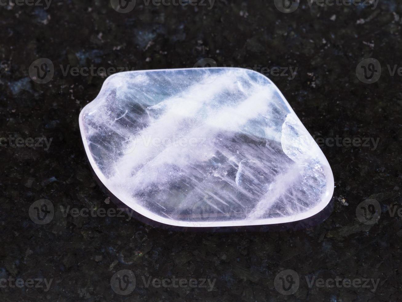 polished pink quartz gemstone on dark background photo