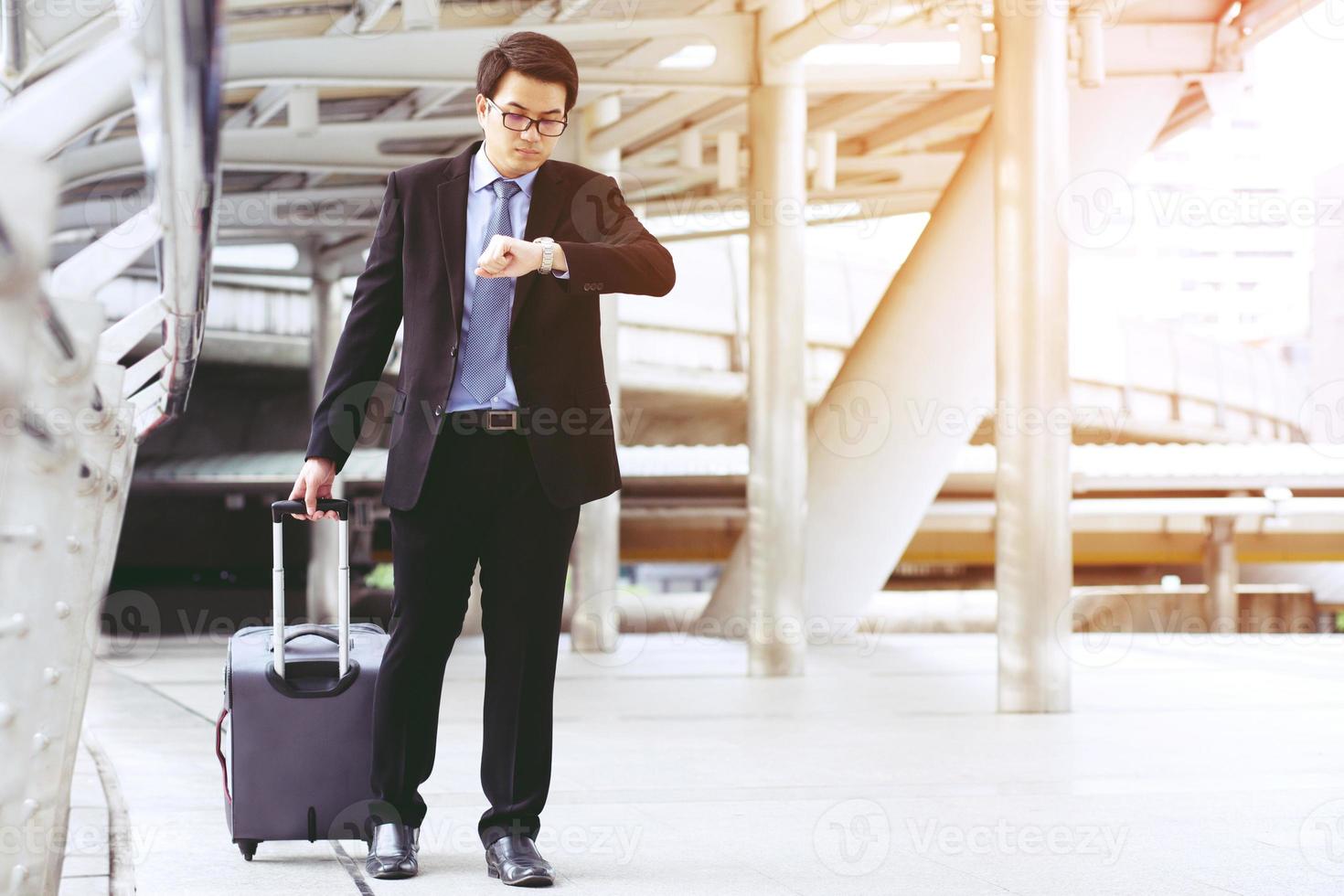 Businessmen drag luggage to head for the airport. photo