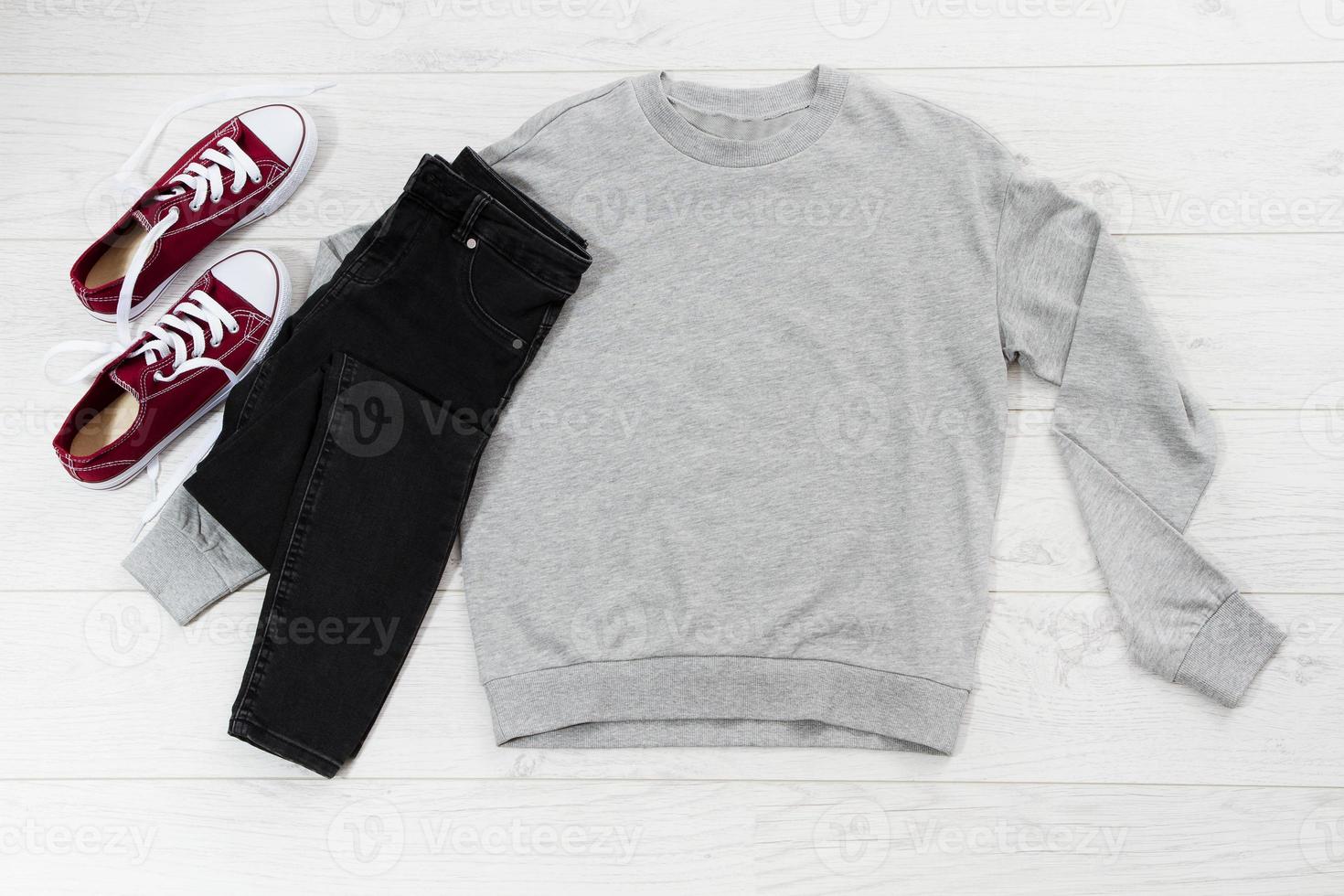 Close up gray blank template sweatshirt hoodie with copy space. Top view mockup pullover on white wooden background. Casual outfit. Flat lay template clothes. photo