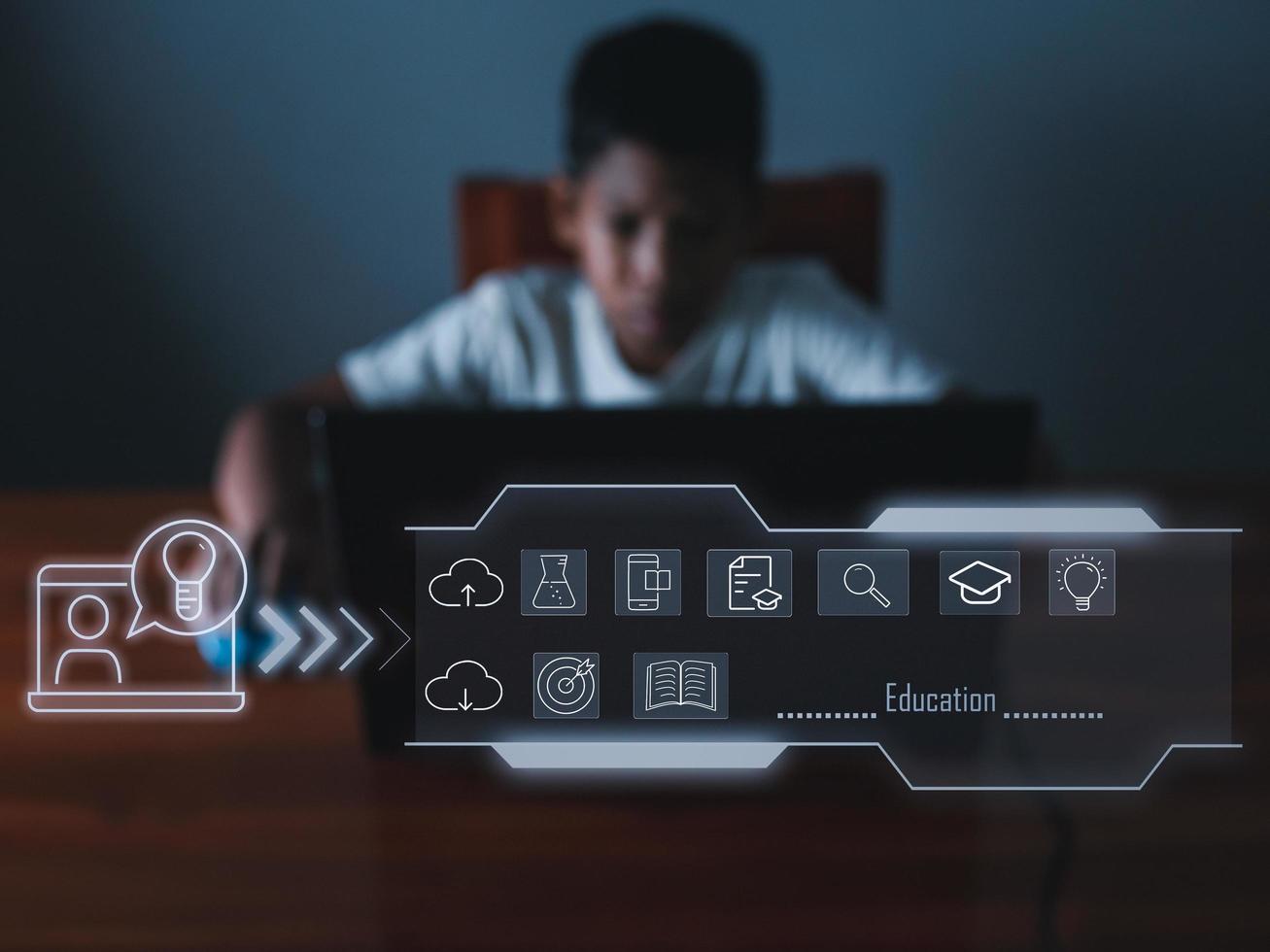 education icon On the background of blurry pictures a boy is staring at a computer monitor. educational concept, educational information search, copy space photo