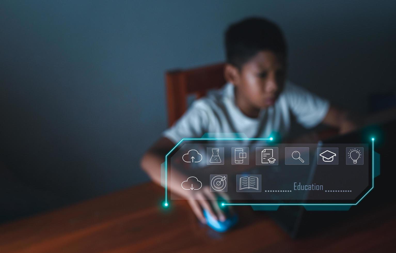 education icon On the background of blurry pictures a boy is staring at a computer monitor. educational concept, educational information search, copy space photo