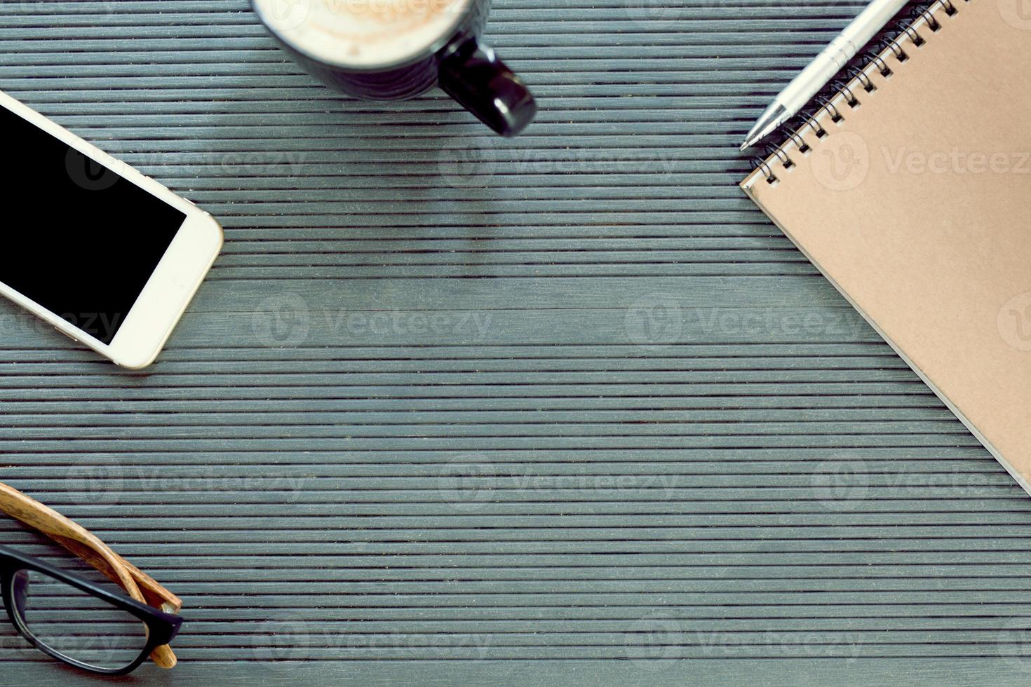 office desk table blank empty with accessories book notepad pen,equipment supplies in the work. coffee cup,mobile smart phone,wrist watch,glasses.Top view with copy space Enter the text.modern office. photo