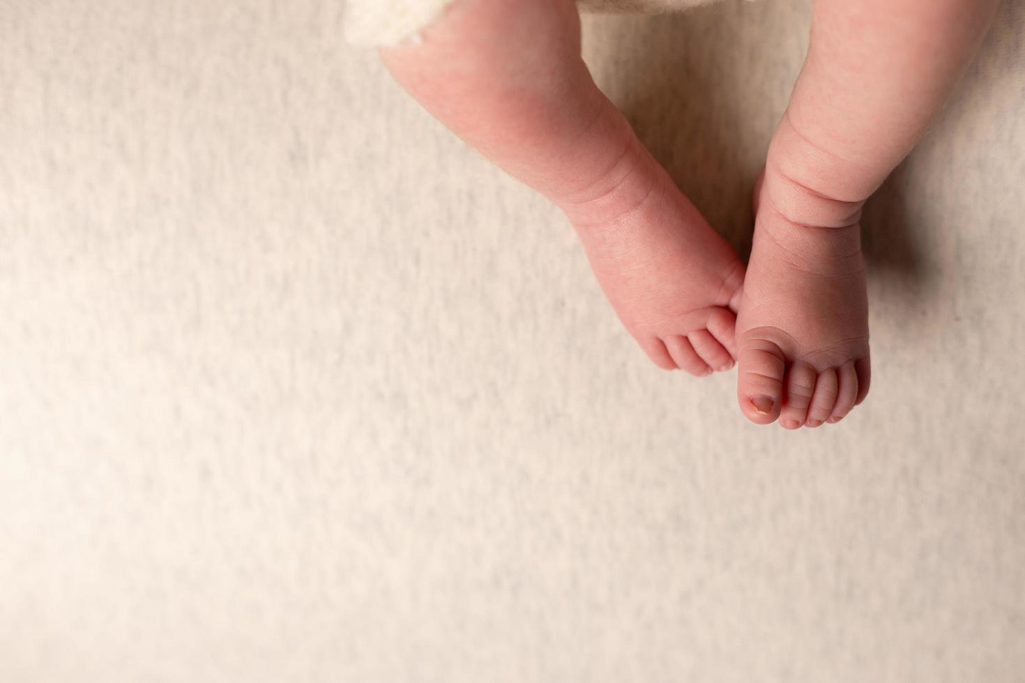 Newborn baby feet on an oatmeal background photo