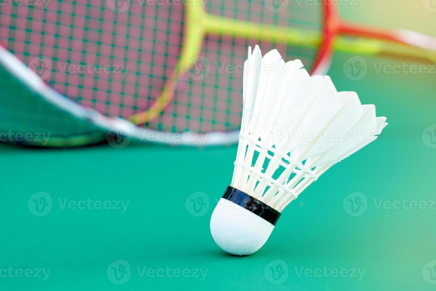 white shuttlecock on green background, blurred badminton racket background. soft and selective focus. photo