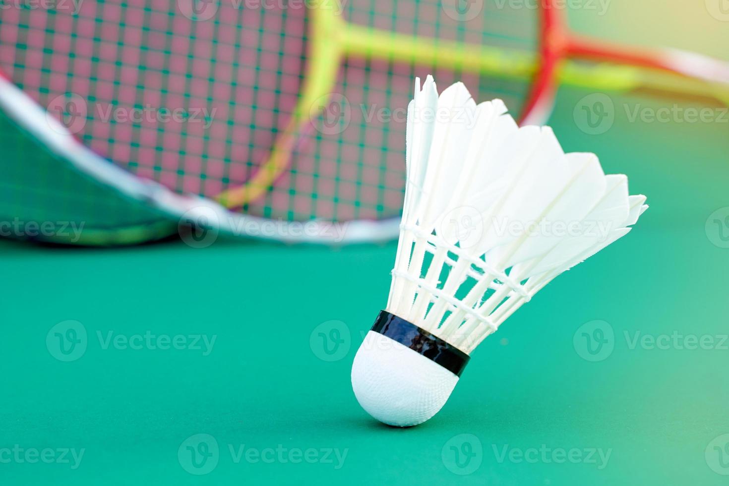 volante blanco sobre fondo verde, fondo de raqueta de bádminton borroso. enfoque suave y selectivo. foto