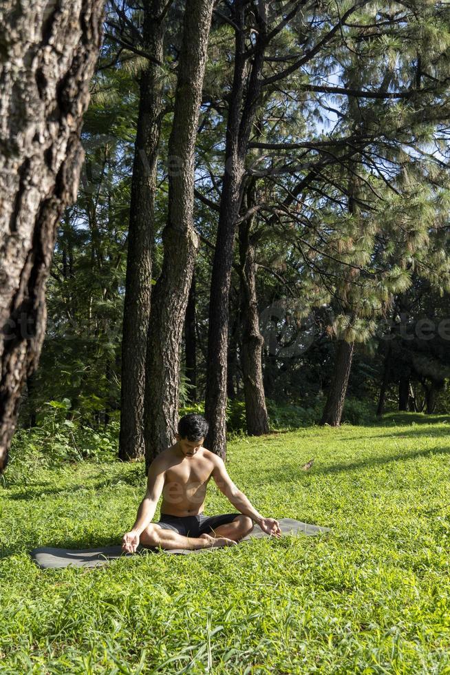 hispanic and latin man, meditating in the middle of a forest, receiving sun rays, brown skin, mexico photo