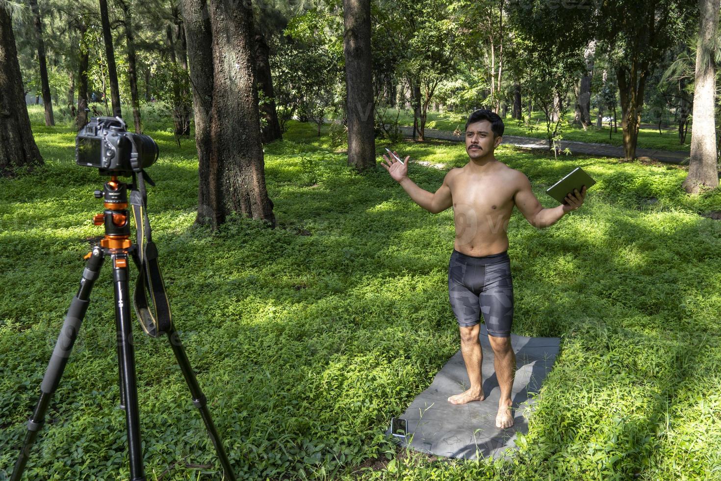 Guy with tablet making video blog on phone. Isolated person giving online classes. Man giving online classes with phone. photo