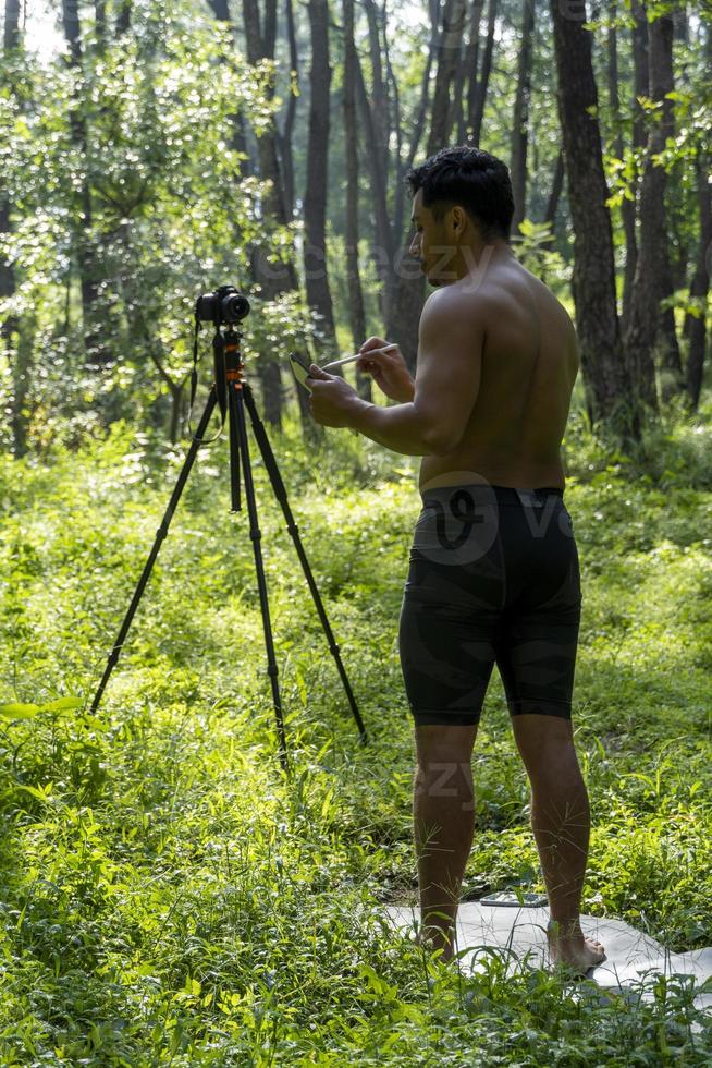 Guy with tablet making video blog on phone. Isolated person giving online classes. Man giving online classes with phone. photo