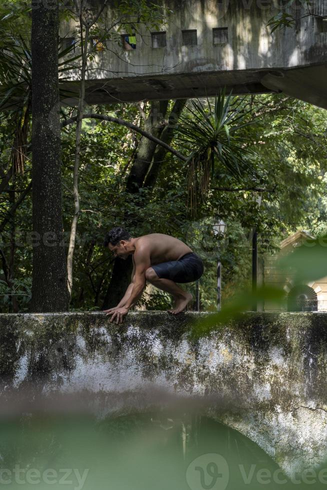 hispanic and latin man, meditating in the middle of a forest, receiving sun rays, brown skin, mexico photo