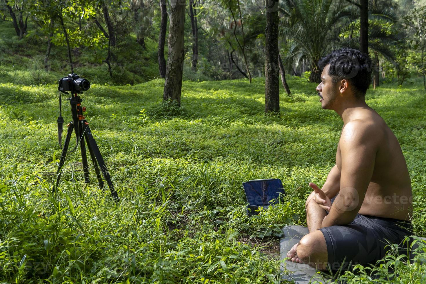 View of a man conducting virtual fitness class with group of people at home on a video conference. Fitness instructor taking online yoga classes photo