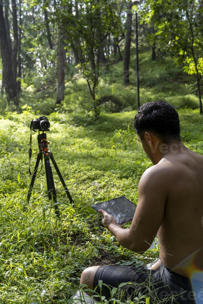 hispanic latino man giving class, while being recorded by a camera, holding tablet in his hand, mexico photo