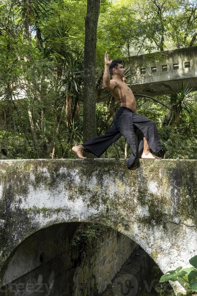 mexican man doing yoga and stretching in the forest, mexico photo