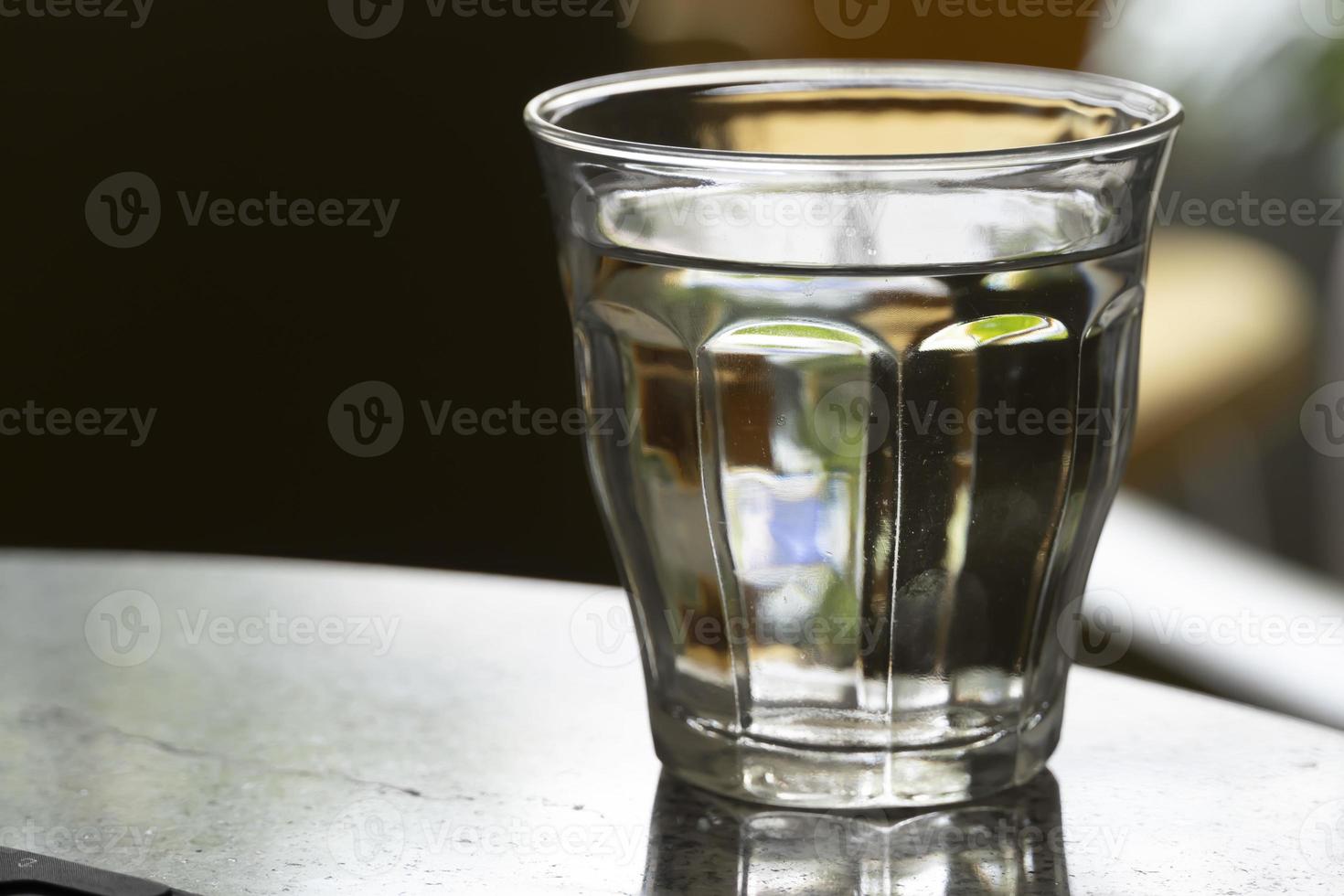 Close up the purified fresh drink water from the bottle on table in living room photo