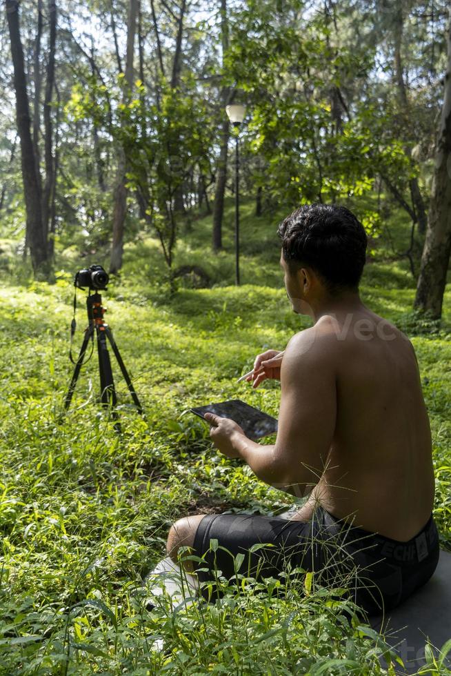 hispanic latino man giving class, while being recorded by a camera, holding tablet in his hand, mexico photo