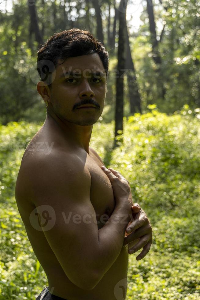 hombre visto de cerca, sin camisa haciendo estiramientos en colchoneta de yoga, ejercicio, américa latina foto