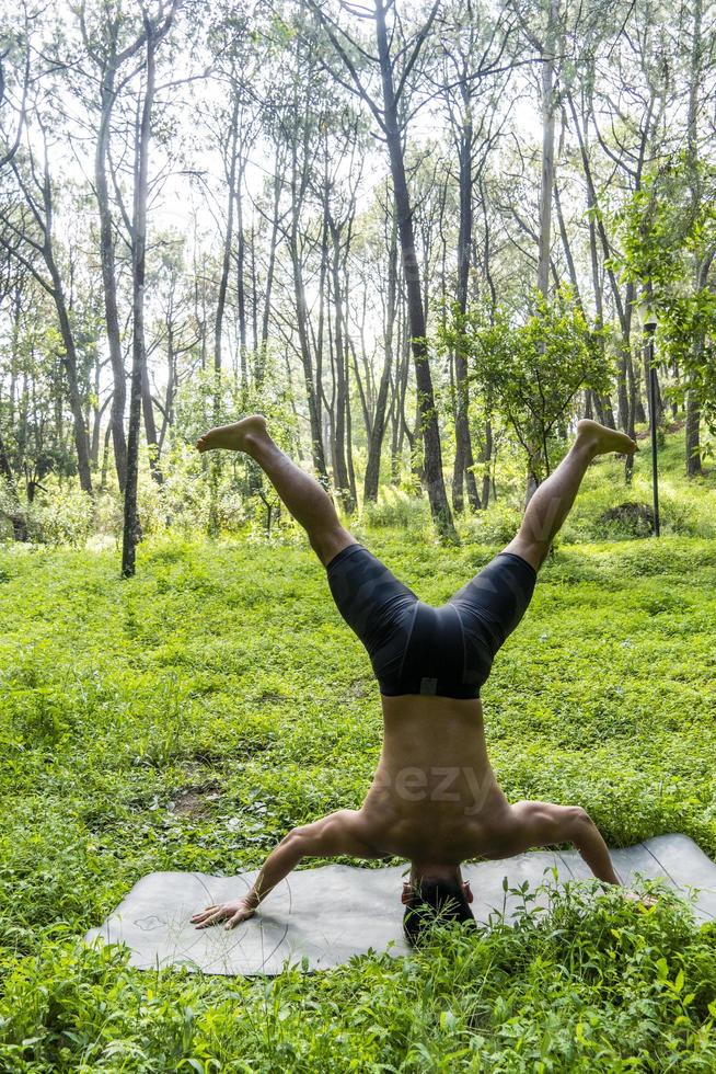 latin american man doing yoga posture, yoga posture, Bee backwards Prsthatah Brahmara, forest photo