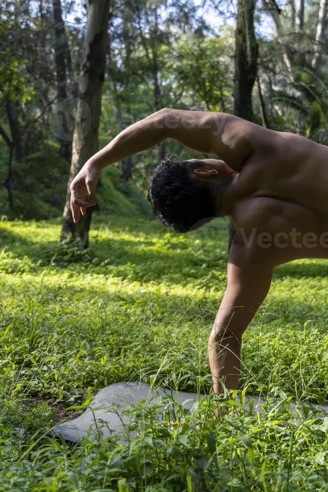 latin american man doing yoga posture, yoga posture, Bee backwards Prsthatah Brahmara, forest photo