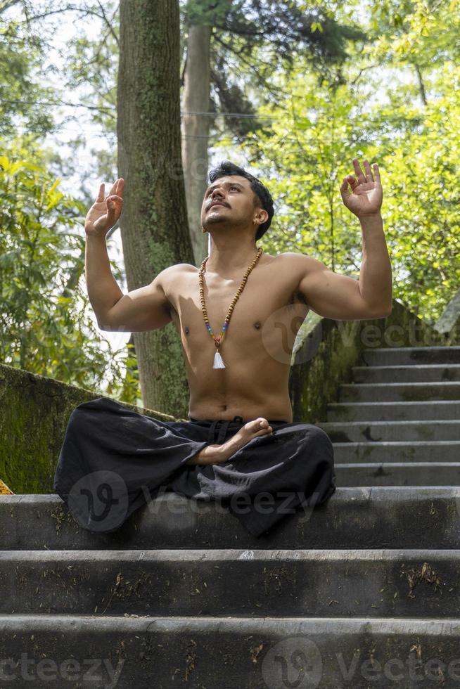 young man doing meditation on a stairway in a forest, mexico photo