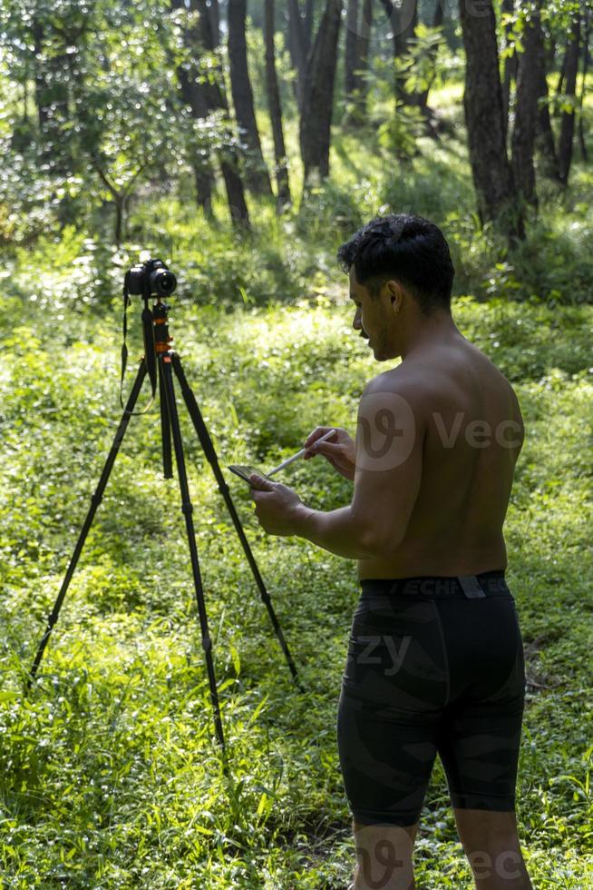 Guy with tablet making video blog on phone. Isolated person giving online classes. Man giving online classes with phone. photo