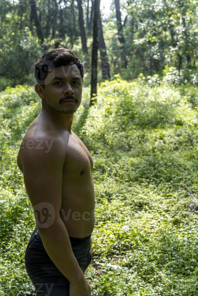 hombre visto de cerca, sin camisa haciendo estiramientos en colchoneta de yoga, ejercicio, américa latina foto