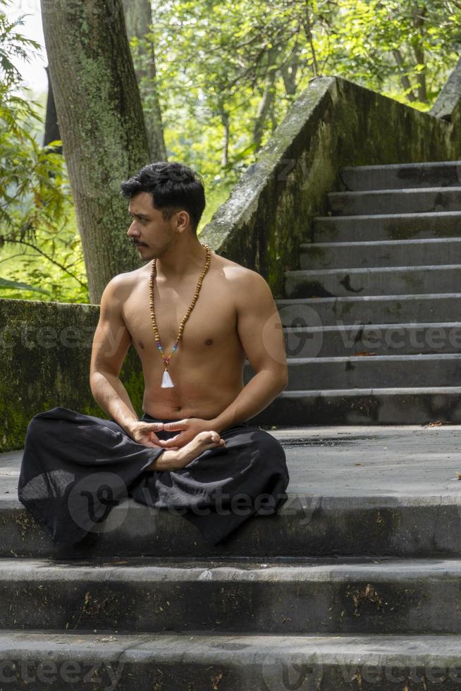 joven haciendo meditación en una escalera en un bosque, méxico foto