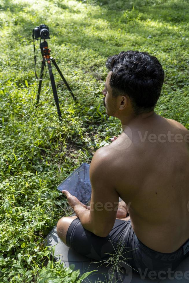 hispanic latino man giving class, while being recorded by a camera, holding tablet in his hand, mexico photo