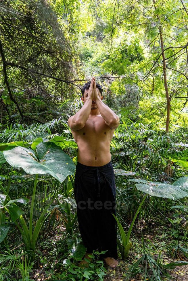 young man doing meditation on a stairway in a forest, mexico photo
