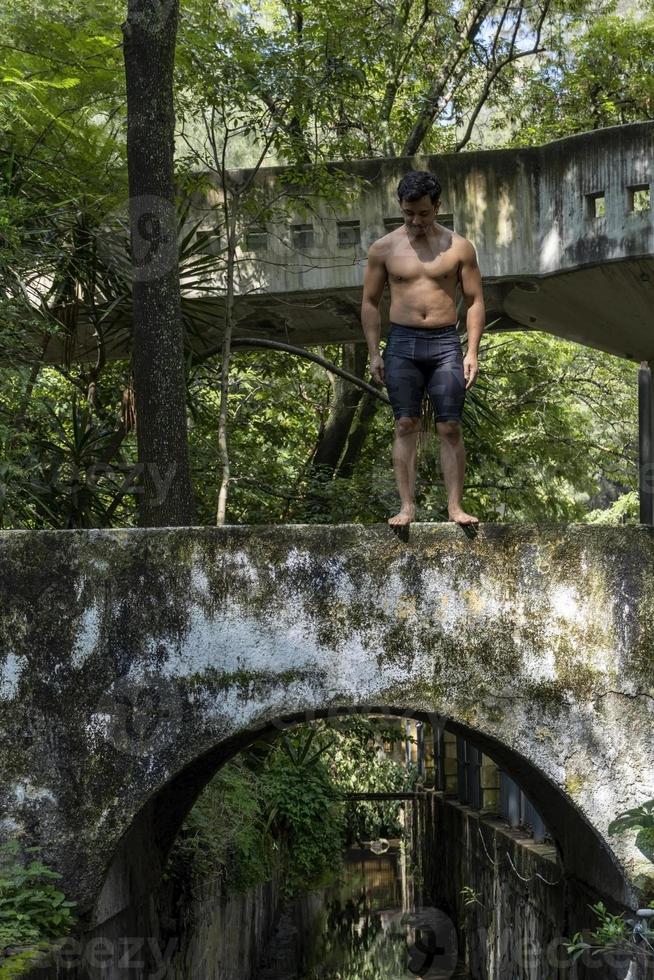 young man, doing yoga or reiki, in the forest very green vegetation, in mexico, guadalajara, bosque colomos, hispanic, photo