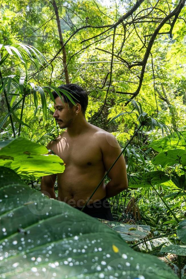 hombre visto de cerca, sin camisa haciendo estiramientos en colchoneta de yoga, ejercicio, américa latina foto