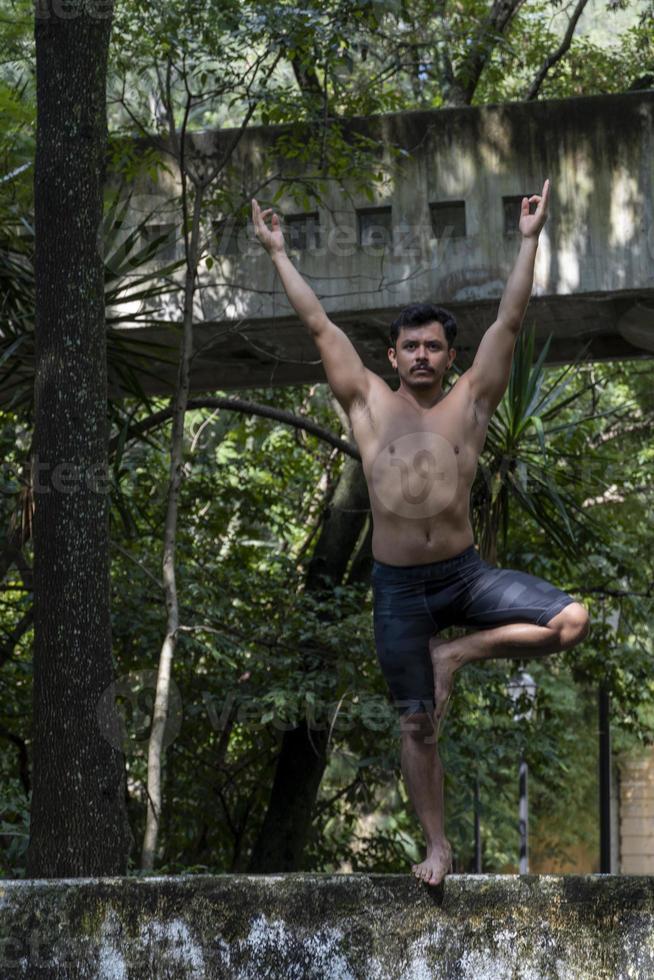 young man, doing yoga or reiki, in the forest very green vegetation, in mexico, guadalajara, bosque colomos, hispanic, photo