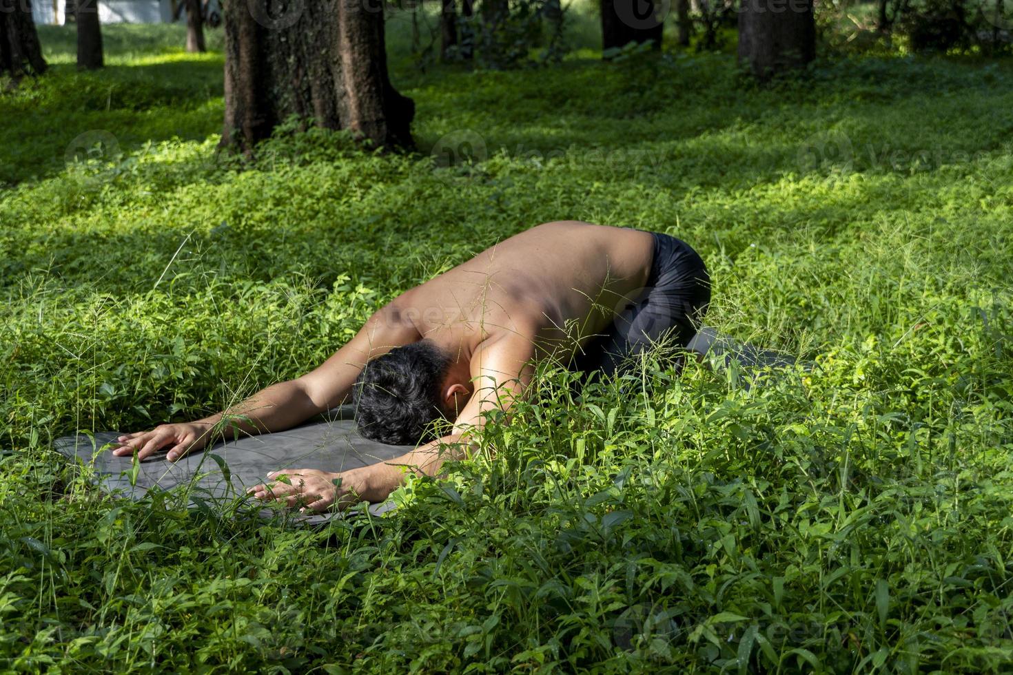 latin american man doing yoga posture, yoga posture, Bee backwards Prsthatah Brahmara, forest photo